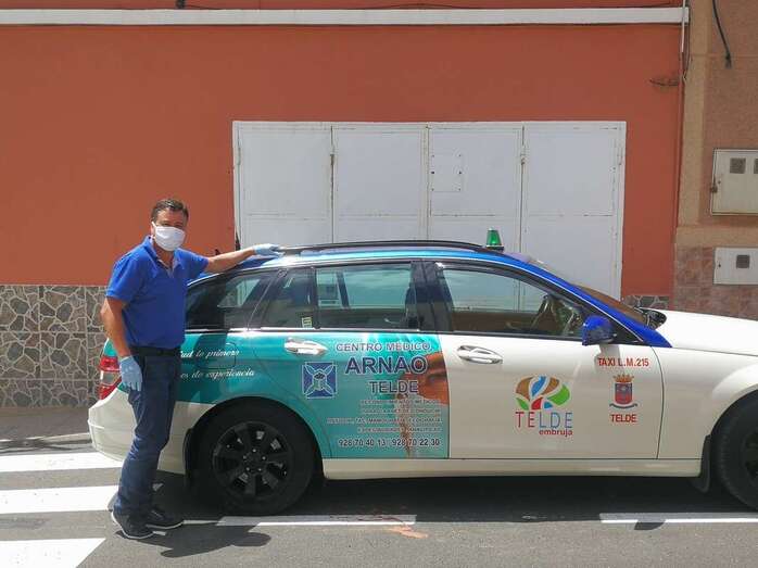 Bernardo Suárez con mascarillas, junto a su taxi (Foto TA)